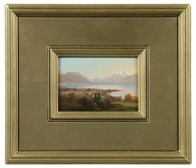 view of alpine village and lake with distant mountains - Hubert Sattler